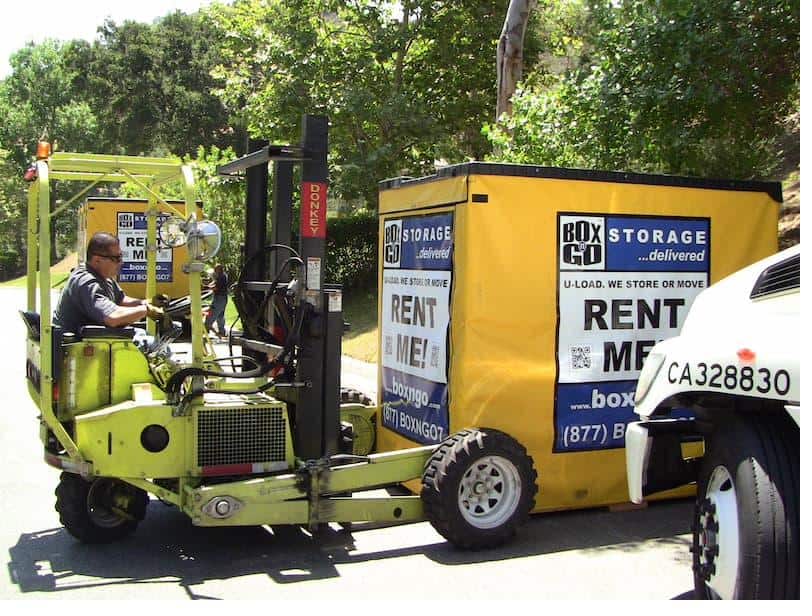 Box-n-Go operator using a truck-mounted forklift to place a Flex portable storage container in a Southern California residential neighborhood