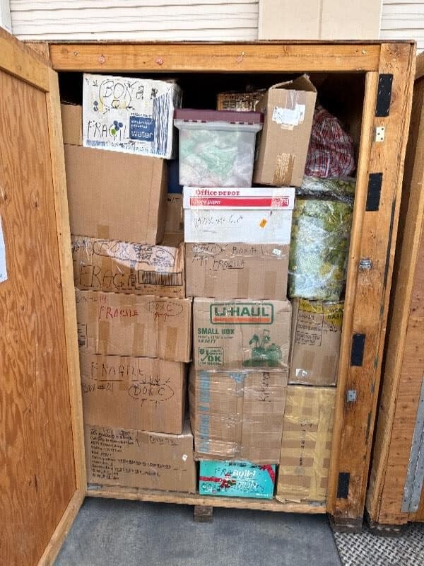 Open Box-n-Go storage container packed with labeled moving boxes, totes, and household goods