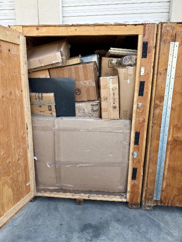 Open Box-n-Go storage container stacked with large sealed cardboard boxes