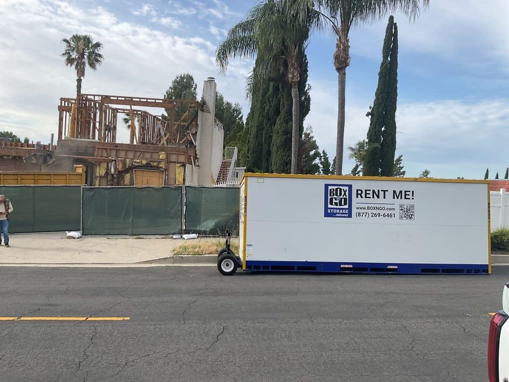 Box-n-Go restoration storage container at the curb outside a fire-damaged Southern California home being rebuilt