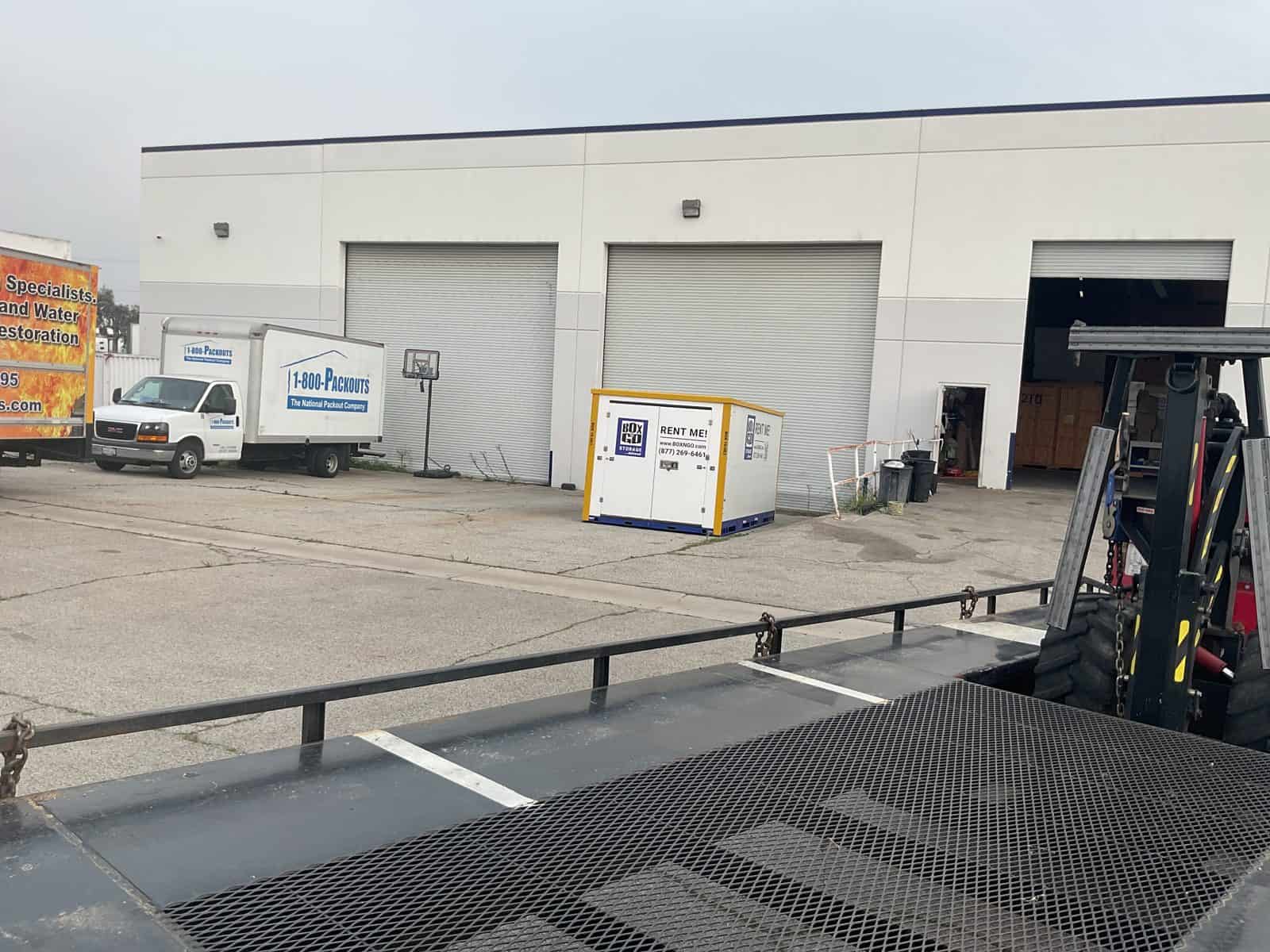 Box-n-Go container beside trucks on a commercial water damage restoration services job